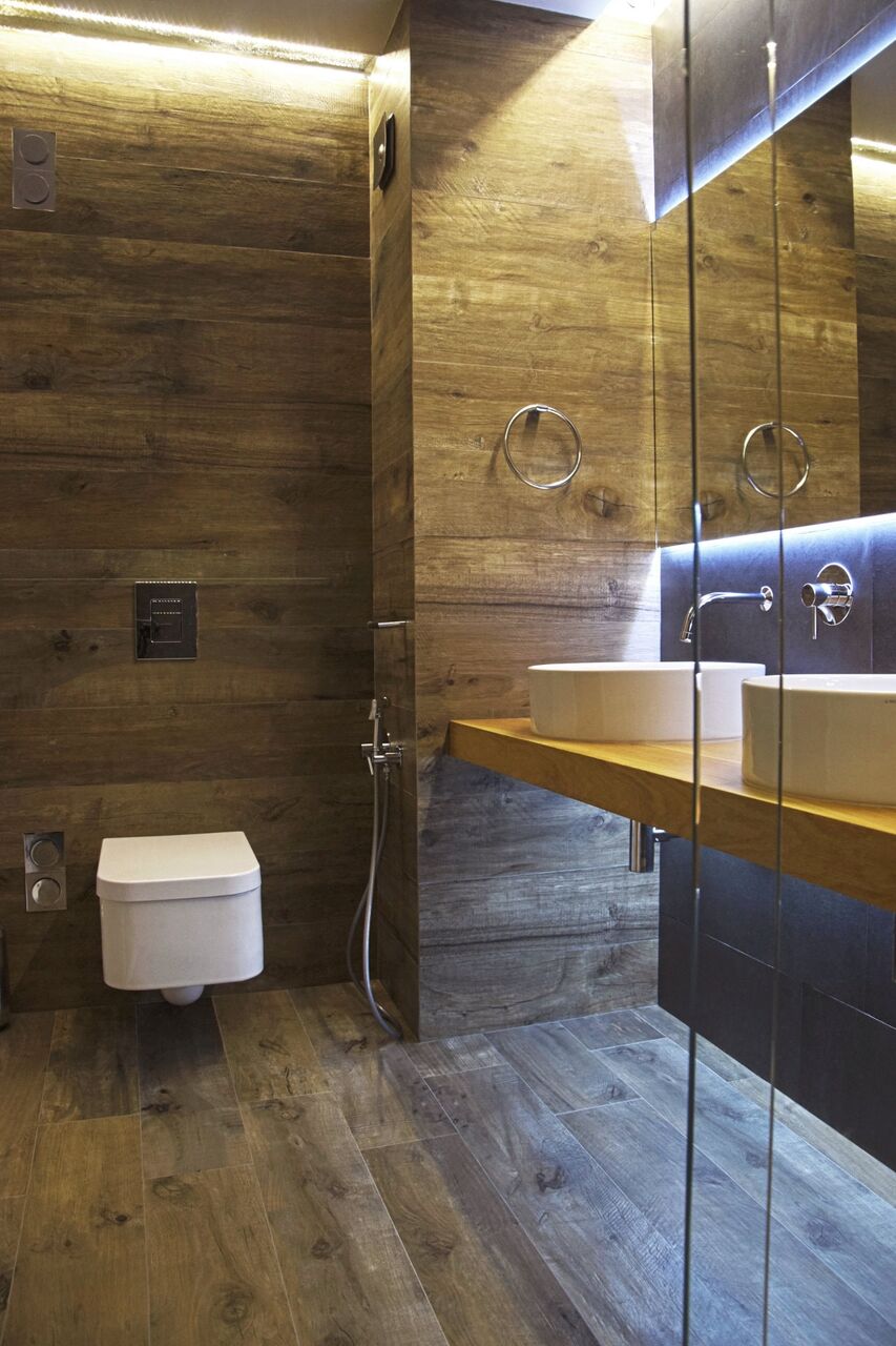 Das WC in holzartiger Bekleidung neben dem Duschglas.