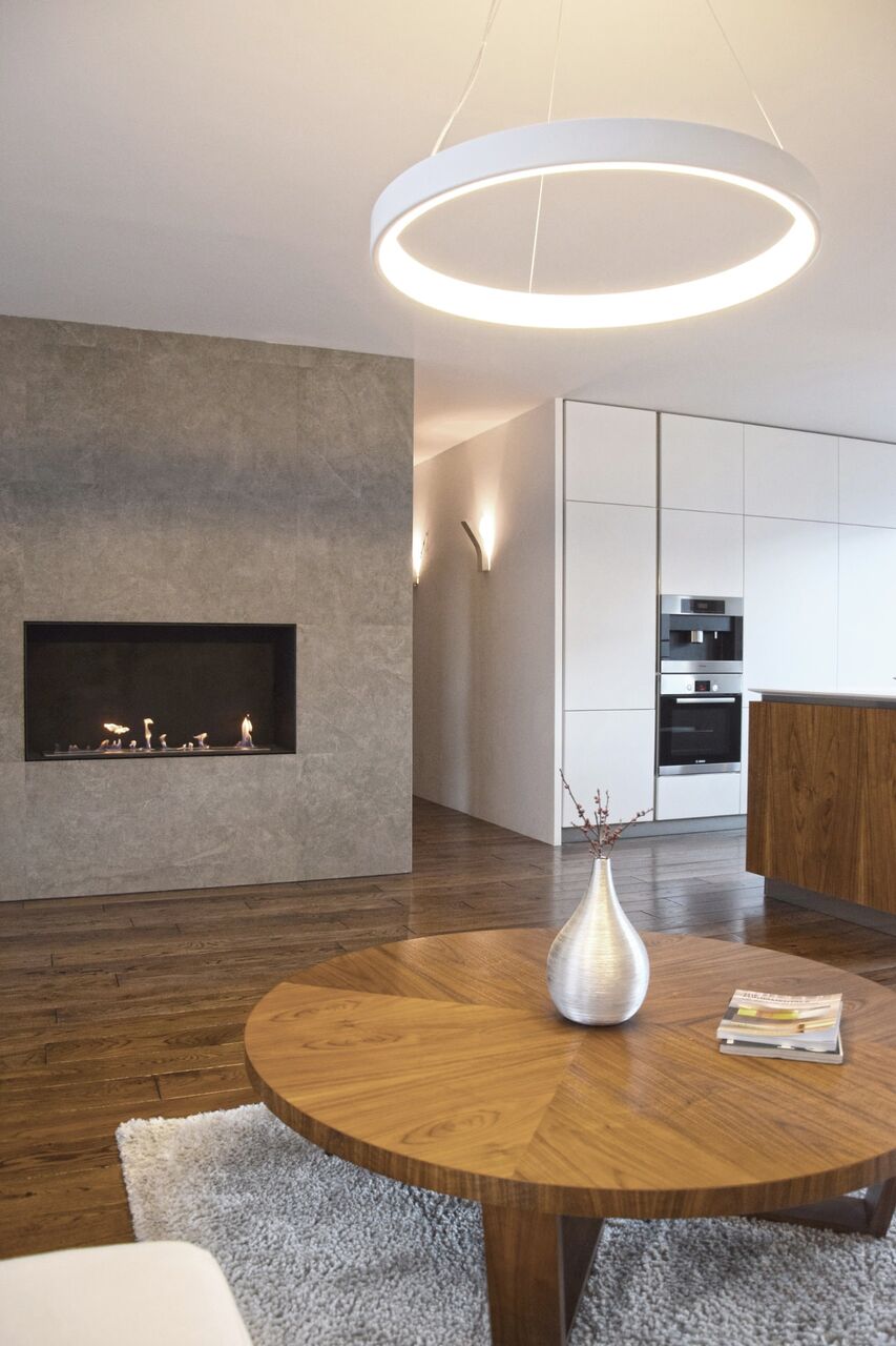 Ringlicht, Kamin und weiße Küchenschränke.