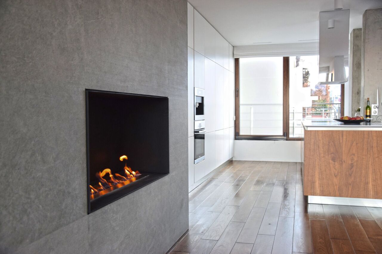Der Kamin im Kubus zum Küchenfenster und zur Insel.