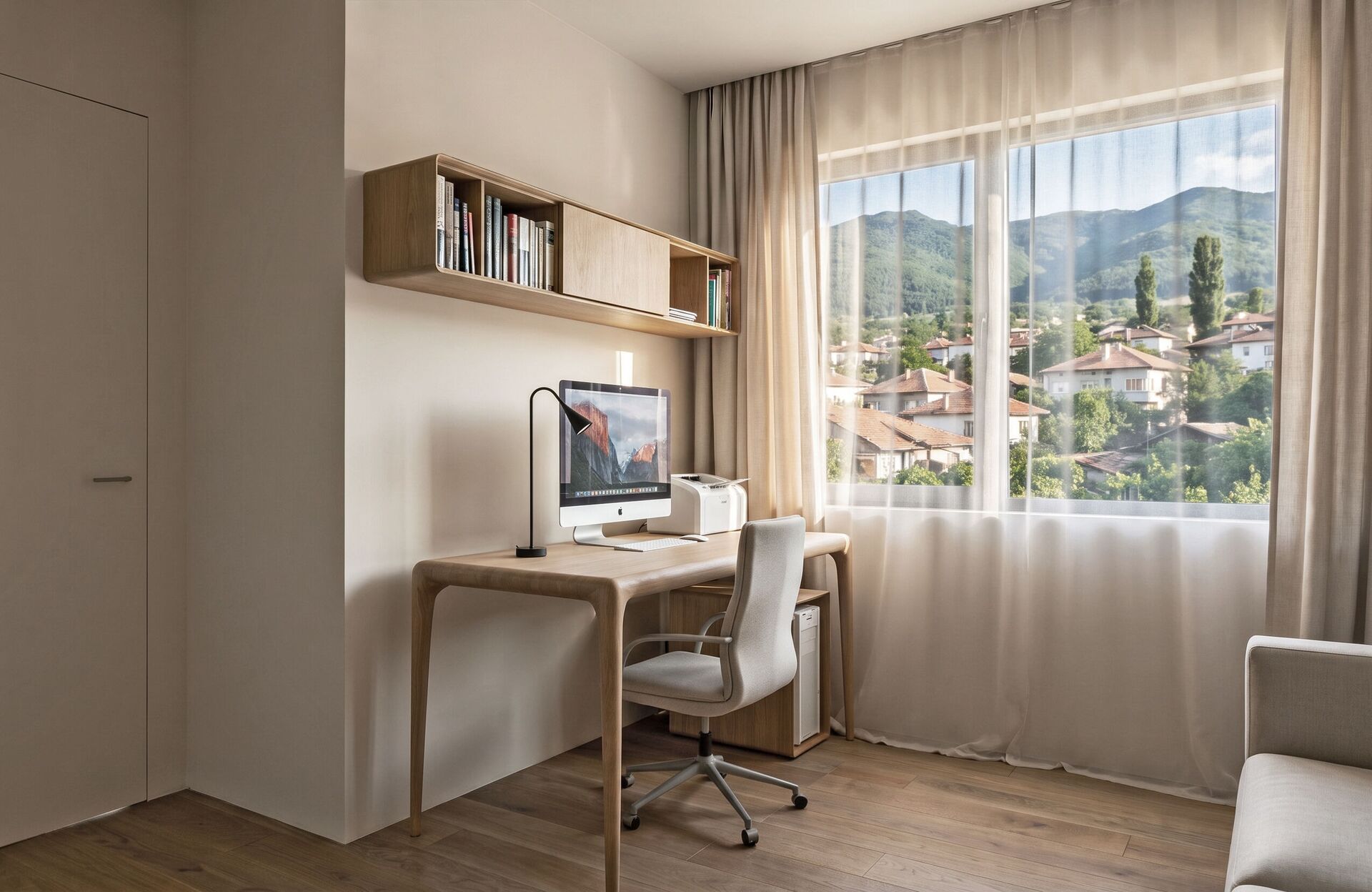 Un escritorio hacia la ventana de tejados del pueblo y colinas.
