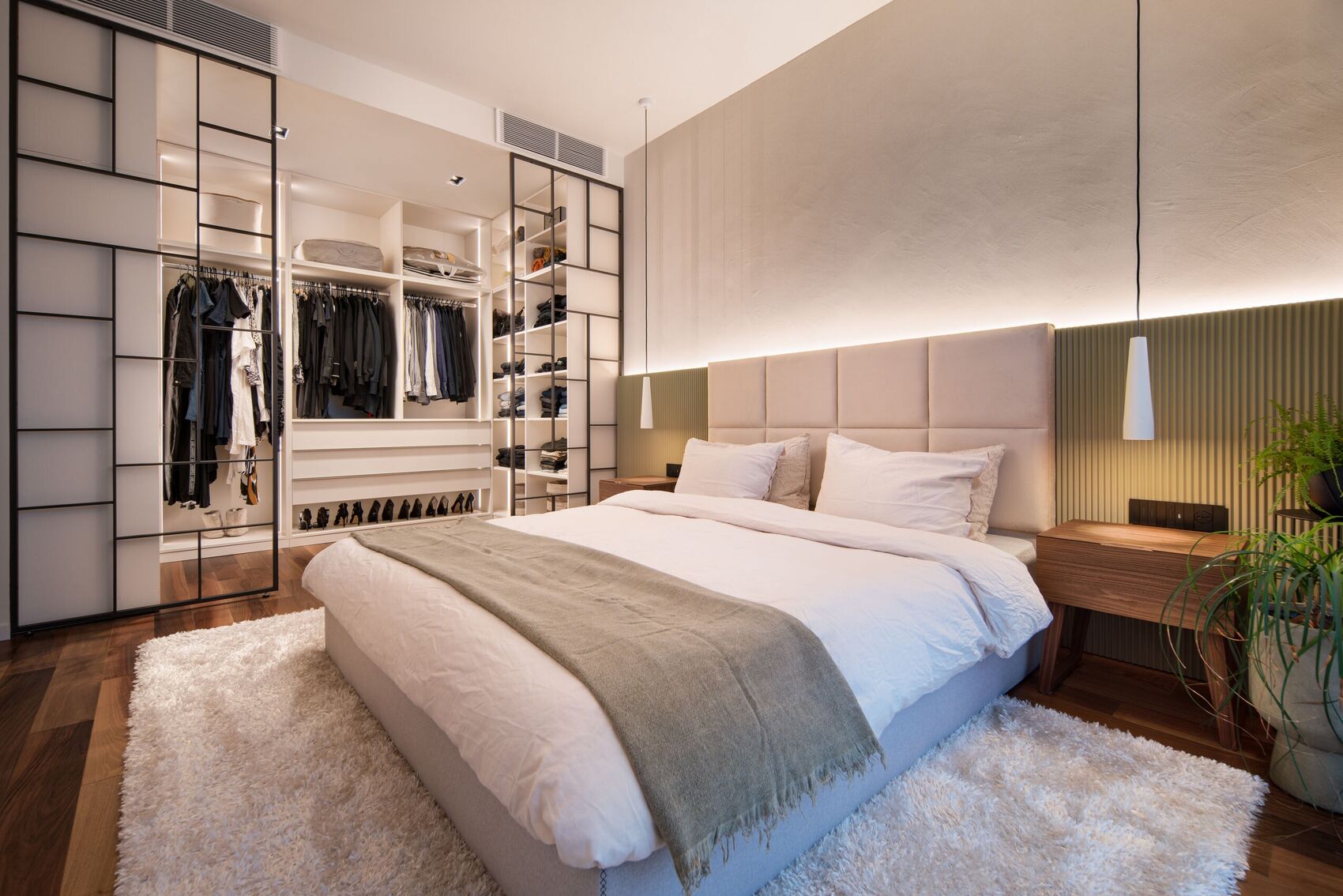 Schlafzimmer zur offenen Ankleide hinter dem Metallraster.