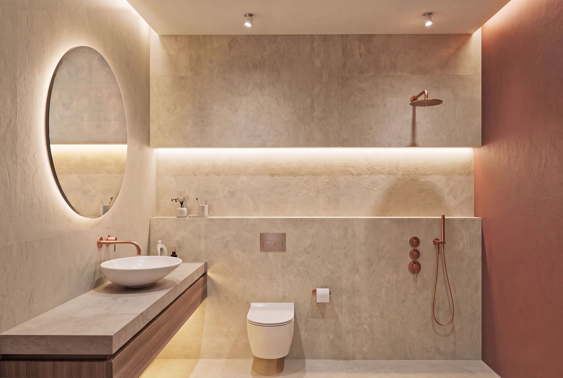 Salle de bain avec un meuble de pierre, des WC suspendus, une douche cuivrée et une niche de terre cuite.